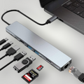 Hub USB tipo C Mi tienda de 8 en 1 en aluminio gris conectado a una laptop con puertos HDMI, RJ45 y lectores SD